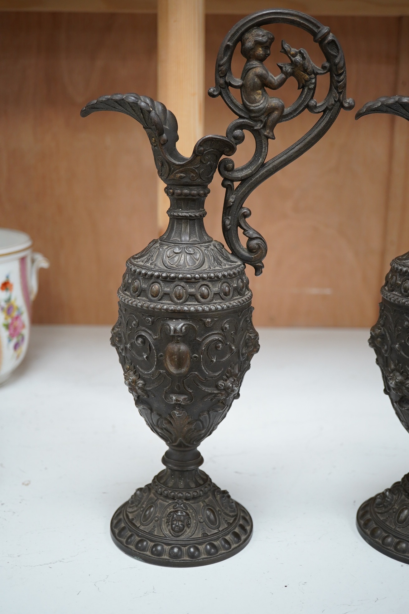 A pair of spelter Cellini ewers, 34.5cm high. Condition - fair to good, some general wear overall